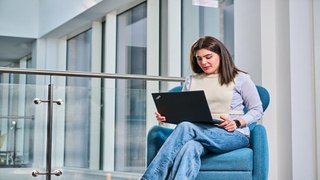 Woman sitting with laptop open