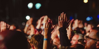 people clapping with their arms raised in the air