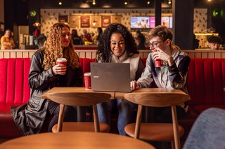 Three students looking at laptop