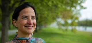 Josefina Braña Varela standing in a grassy park beneath a canopy of trees.
