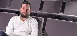 Manolo Mantero seated in a cinema