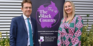 Two key members of a conference standing looking at camera