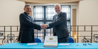 Vice Chancellor shaking hands with representative from Pharo University