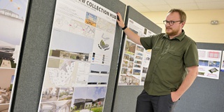 Student surveys his architecture display at RAF Museum