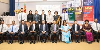 A group of attendees sitting and looking at the camera at the launch event for new degrees