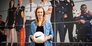 Kerys Harrop former Lioness holding a football in front of WLV Sport centre