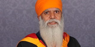 Portrait of Honorary Graduate Manny Kang holding his award