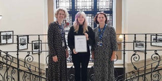 Student Alisha holding up her certificate award