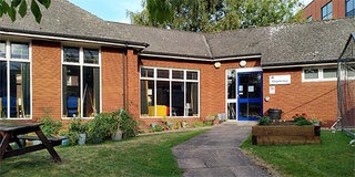 the Chaplaincy garden with picnic table and flowerbeds, in front of the Chaplaincy building