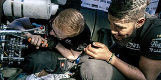 An image of two Motorsport students engineering a race car