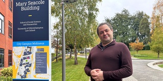 Academic standing outside one of the Business School buildings
