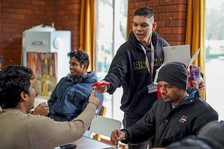 Student handing out fortune cookies at the Chinese New Year lunch at the Chaplaincy