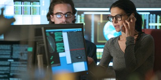 A picture of two researchers surrounded by text and computers