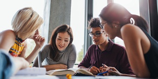 A group of students studying together sitting at a table