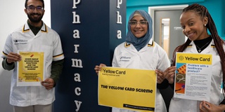Pharmacy students holding Yellow Card posters