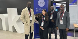 Computer science students standing looking at the camera at the IBM conference