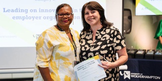 An apprentice receiving her award for studying for a Master's Leadership degree apprenticeship