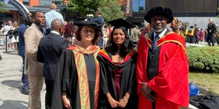 Prathima Morbagilu Nagabhushana in graduation robes standing with professors