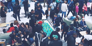 photo of large group of students having fun play table football taken from above