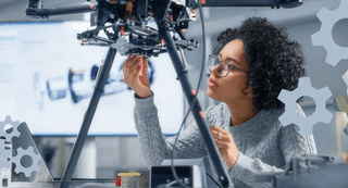A female engineer works on a drone in a lab