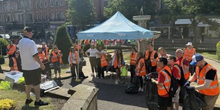 Photograph of volunteer litter pickers  in high-vis jackets garthered in Wolverhampton city centre with Enjoy Wolverhampton gazebo in background