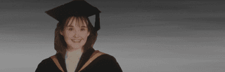 Debra Cureton in her graduation robes before a grey backdrop