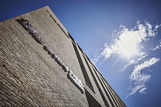 Photo taken of the business campus looking upwards towards the sky, there's a cloud floating high above