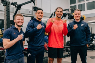 Ben Whittaker with two students and a lecturer in a gym setting