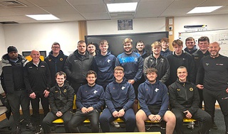 15 football coaching students, dressed in blue tracksuits, gather together with their lecturers for a group photo at the Challenger Recruitment Day