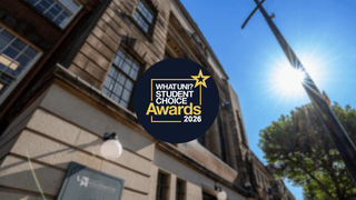 A picture of the outside of Wulfruna House, looking skyward. The WhatUni Awards 2026 emblem is in the centre on dark blue disk with white and gold writing