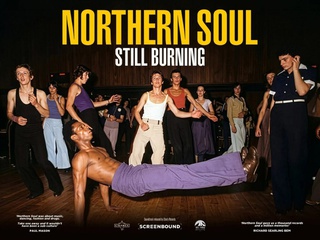 A picture of teenage boys and girls, dressed in typical Northern Soul style clothing of vests and flared trousers, dancing in a club. The central dancer wears purple flares and no top and is undertaking a dance move on the floor.