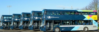 A parked line of five blue double decker buses with University of Wolverhampton branding