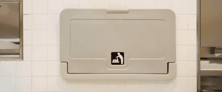 A graduate in robes and their parents posing for an iPhone photograph