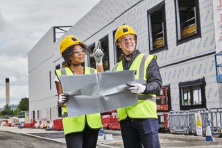 Two construction contractors overseeing a site