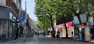 Wolverhampton city centre high street with many storefronts at the sides of the walking path