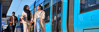 Student's walking long tram station platform as the tram rides away.