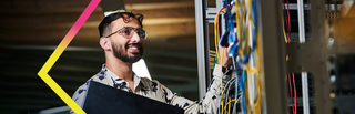Banner photo of a postgraduate student working with networking equipment.