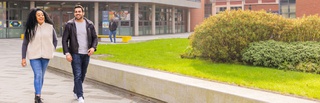 Two students walking across the courtyard at the University of Wolverhampton's City Campus.