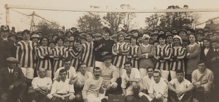 A group photo from WW1 of a men and women's football team